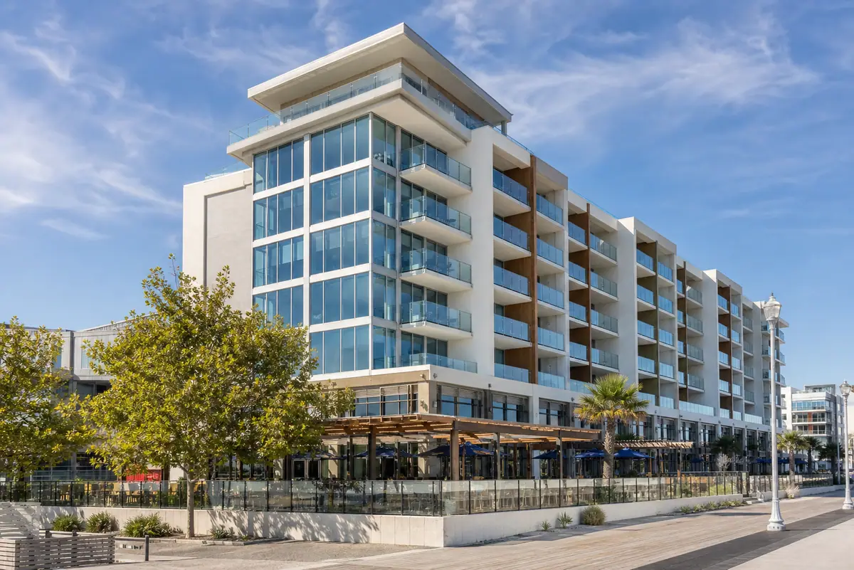 Photoreal exterior of Cambria Hotel Ocean City - Bayfront beside calm bay water